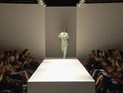 WS Woman in medical scrubs modeling on catwalk while audience applauds / London, England, UK Stock Footage