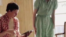 Young couple sit and browse tablet computer on motel bed Stock Footage