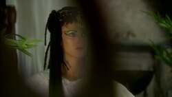 Younger ancient Egyptian female wearing white robes with eye make-up and braided hair Stock Footage