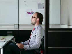 MS DS businessman sitting in office holding digital tablet in discussion/Seattle, Washington, USA Stock Footage