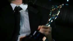 Celebrity holds awards trophy with pride and smiles for cameras at awards show Stock Footage