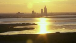 Mobile, Alabama skyline over marsh and rivers at sunset. Stock Footage