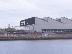 Harland and Wolff Factories by river in Belfast, pan left, Northern Ireland Stock Footage