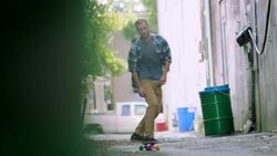Young man skates through downtown alley on longboard Stock Footage