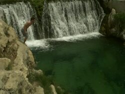 High Speed Man jumping from rocks in to waterfall pool. (Individual frames may also be used as a still image. Each frame in its raw state is about 6MB or about 12MB as a 16 bit TIFF) Stock Footage
