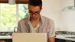 Young man, laptop, glasses, kitchen. Stock Footage
