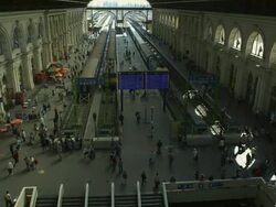 Day time-Establishing interior shot of main train station with people walking around.  Slow pan from staircase to train Stock Footage