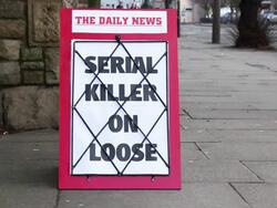 Newspaper headline board - Serial Killer on Loose Stock Footage