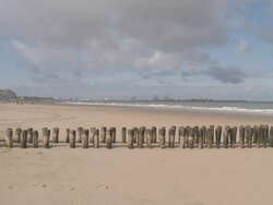 WS View of wave breaker at beach of Knokke with Zeebrugge terminal / Ostend, Flanders, Belgium Stock Footage