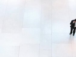  HA Businessman standing on large empty tiled floor talking on cell phone / Seattle, Washington, United States Stock Footage