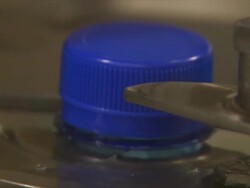 CU Machine tightening blue plastic bottle caps on plastic water bottles / Wau, Western Bahr el Ghazal, Sudan  Stock Footage