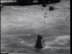B/W 1961 AERIAL Alan Shepard being lifted from space capsule in ocean to hovering helicopter Stock Footage