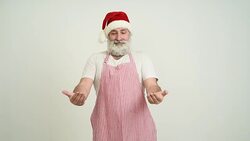 Adult senior man showing a copy space in the Santa Claus hat on a grey background Stock Footage