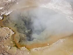 MS Shot of reddish brown and dark green geyser pool with vapour rising / Geiser del Tatio, Atacama desert, Chile Stock Footage