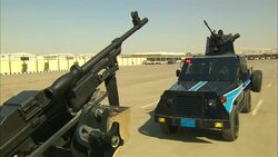 A machine gun swivels atop an armored truck on a military base in Saudi Arabia. Stock Footage