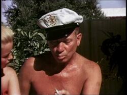 Close up Harpo Marx performing trick by inhaling cigarette and blowing bubble w/smoke coming out Stock Footage