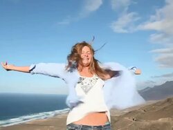 Teenage girl braces against wind, arms outstretched Stock Footage
