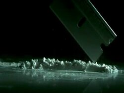 SLOMO CU razor blade falling on to cocaine powder Stock Footage