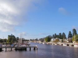 WS Clouds drifting over sleepy hamlet of port fairy and boats moored on Moyne river / Port Fairy, Victoria, Australia Stock Footage