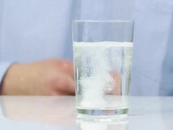 Male hand drops effervescent tablet into the glass Stock Footage