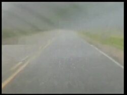 MWA from POV of vehicle, Driving along road during heavy hail storm, Grey sky, Windscreen wipers on, USA Stock Footage