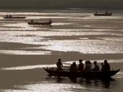 WS TS Boats passing across Gangas river at sunset / Varanasi, Uttar Pradesh, India Stock Footage