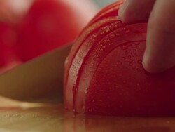 CU Half organic tomato on kitchen chopping block, slice with steel knife / Los Angeles, California United States Stock Footage