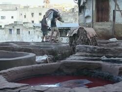 MS Shot of two men working with fabric and large vats of various dyes / Casablanca, Centro, Morocco Stock Footage