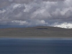Pan Right Shot Rakshastal Lake with hills and clouds Lhasa Tibet China Stock Footage