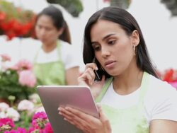 MS PAN Woman talking on cell phone in floral business / Richmond, Virginia,United States Stock Footage