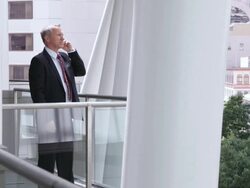  WS Businessman standing on balcony talking on cell phone, then hanging up and leaning on railing / Seattle, Washington, United States Stock Footage