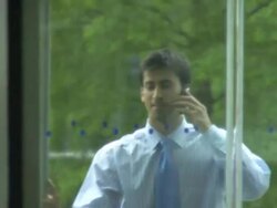 Man walking through door in office on phone; UK Stock Footage