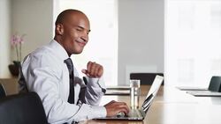 Smiling businessman at conference table using laptop Stock Footage