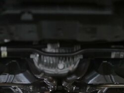 MS TD Mechanic working under car with his arms above his head within vehicle / Seattle, Washington, United States  Stock Footage