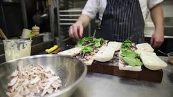 Chef making sandwiches with spinach in commercial kitchen Stock Footage