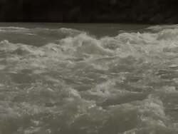 Long Shot hand-held zoom-in - A kayakar fights through thick rapids / USA Stock Footage