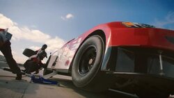 Pit crew jacks race-car and removes lug-nuts, man runs with tire Stock Footage