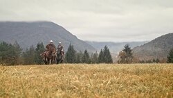 SLO MO Two cowboys riding galloping horses in mountains Stock Footage