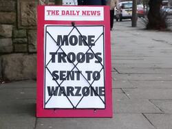 Newspaper Headline Board - More troops sent to Warzone Stock Footage