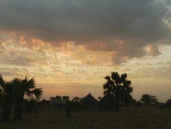 WS Sunset over rural village and huts / Gogrial, Warrap State, Sudan Stock Footage