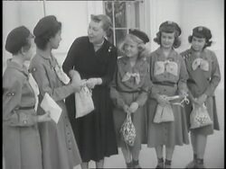 First Lady Bess Truman places items in bags for a group of Girl Scouts. News Clip