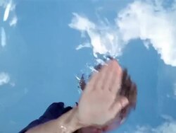 LA CU boy smiling and running hand across surface of water Stock Footage