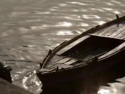 MS Two people bathing in Gangas River near docked boat / Varanasi, Uttar Pradesh, India Stock Footage