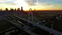 Sun rays beam along the horizon as Downtown Dallas Texas sits in front of the sunrise Dallas Texas Stock Footage