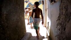 Young Brazilian boys walk through alley with graffiti of Sugarloaf and Christ the Redeemer Stock Footage