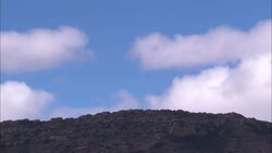 Clouds float over a hill. Stock Footage