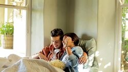 Teenage couple cuddling with blanket throwing popcorn overhead Stock Footage
