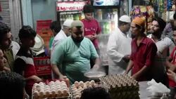 A popular street vendor prepares different types of eggs in a pan with an open flame for his customers during Ramadan Stock Footage