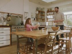 MS Shot of Daddy & daughter get ingredients ready in kitchen then high fine / London, United Kingdom  Stock Footage