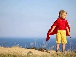 Superman boy plays on the coast Stock Footage